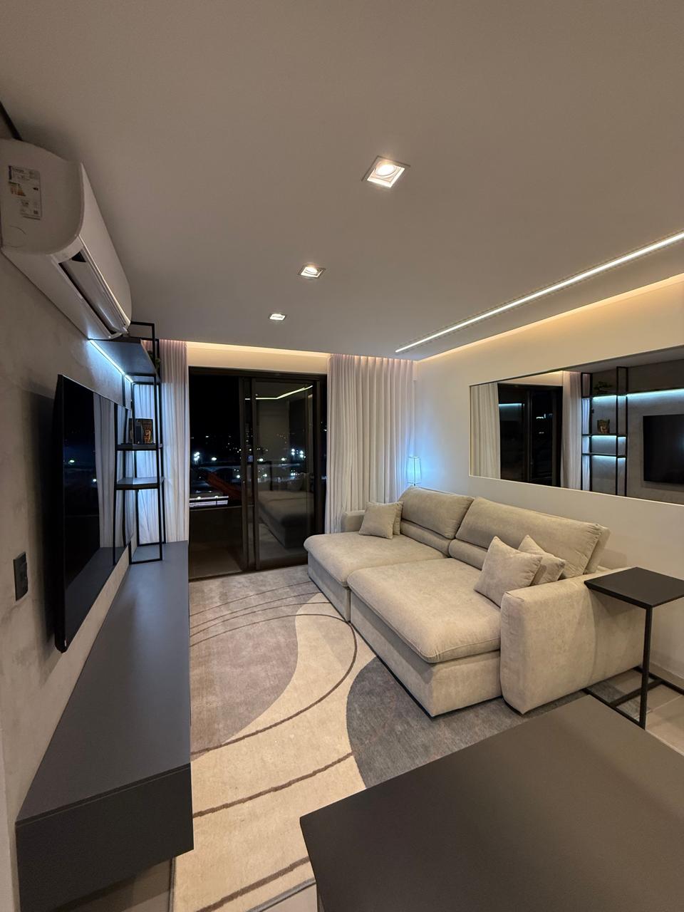Sala com Smart TV, iluminação embutida e acesso à varanda